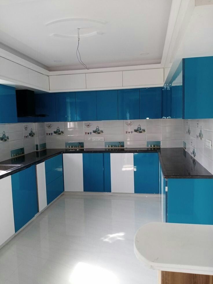 an empty kitchen with blue and white cabinets