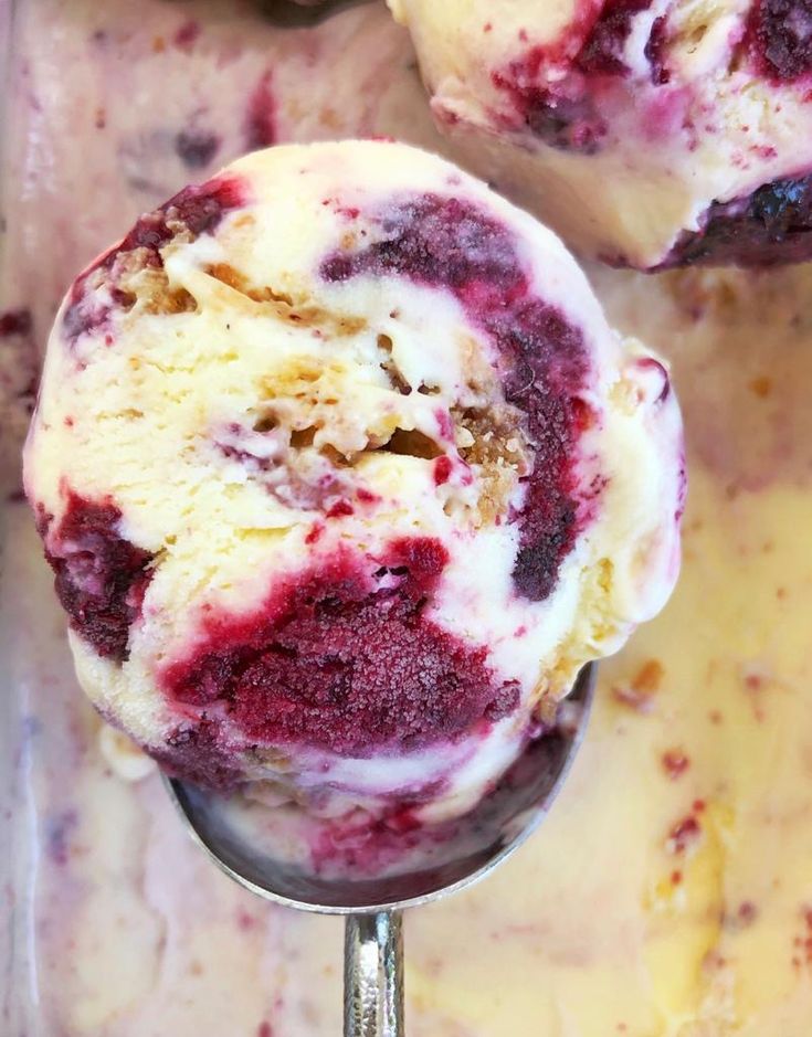 two scoops of ice cream sitting on top of each other with raspberries