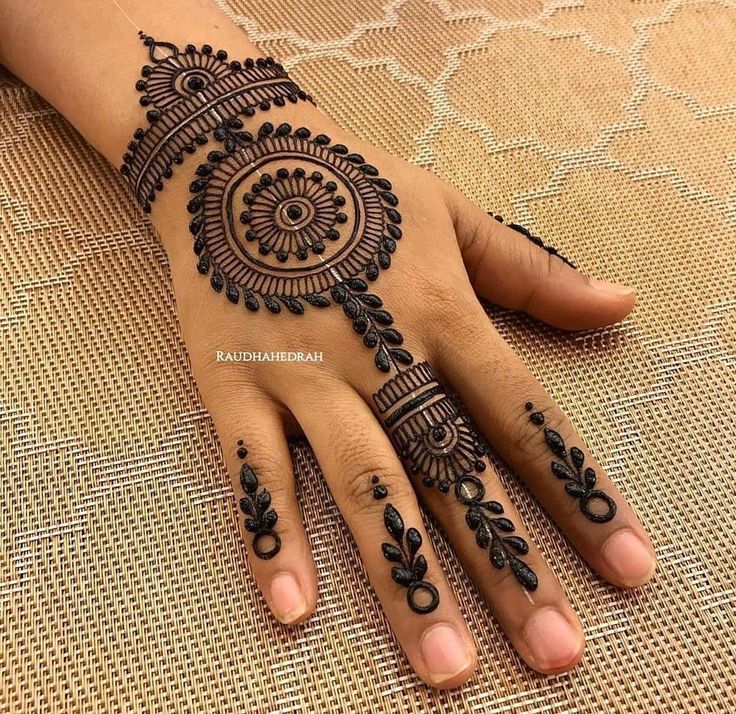 a woman's hand with henna tattoos on it