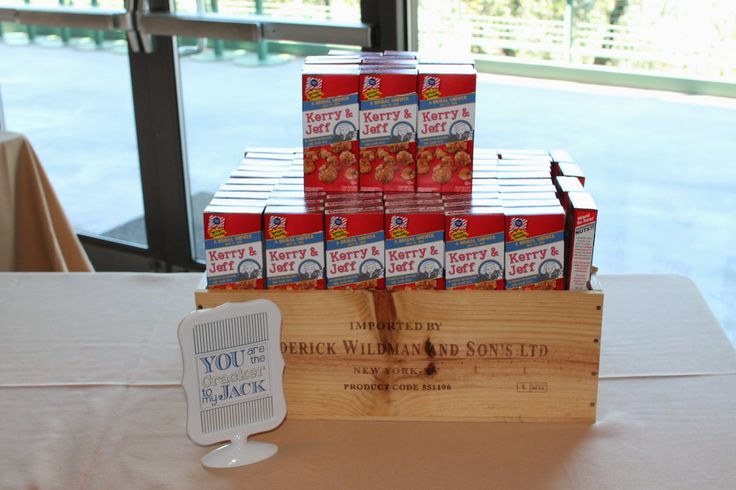 a wooden crate filled with lots of canned food sitting on top of a table next to a window