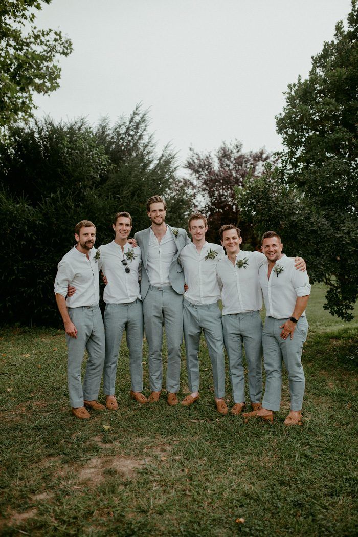 a group of men standing next to each other on top of a lush green field