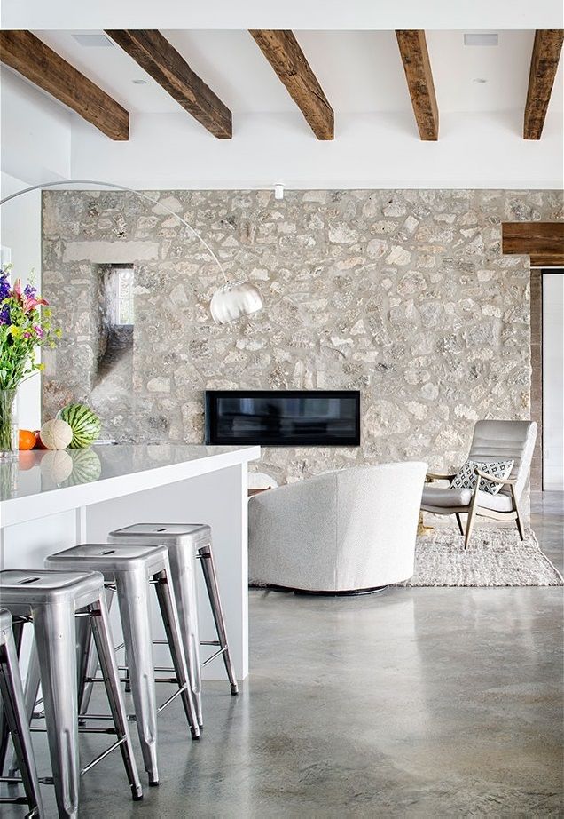 a living room filled with furniture and a flat screen tv mounted on a wall next to a bar