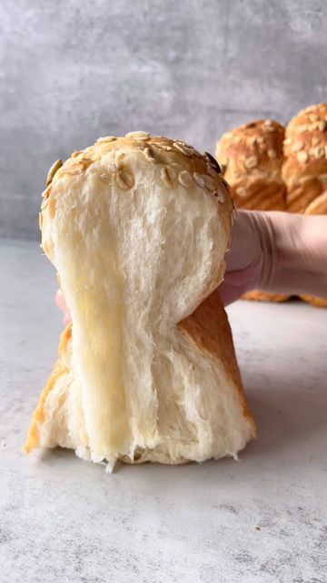 a person holding a piece of bread in their hand