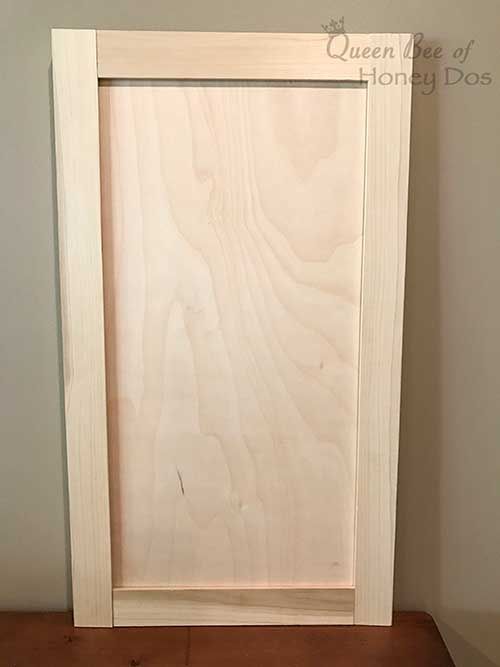 an unfinished door is sitting on top of a wooden shelf in the corner of a room