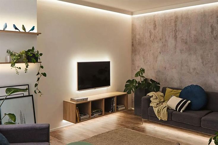 a living room filled with furniture and a flat screen tv mounted on a wall next to a wooden floor