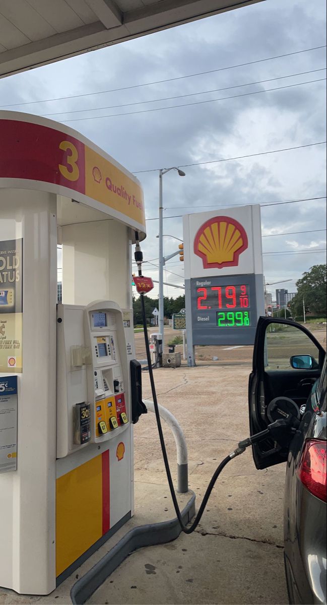 a shell gas station with a car at the pump