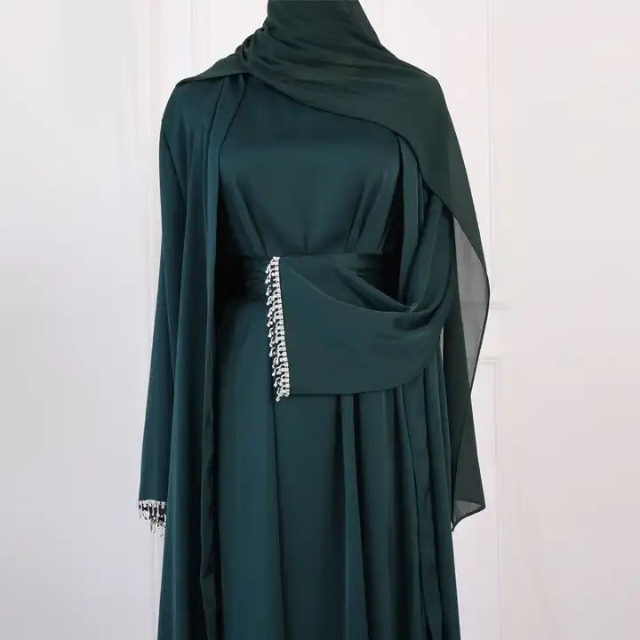 The Danya Diamond Dazzle Open Abaya Set (2-Piece Set) is a stunningly elegant open abaya set made of satin and with a dazzling diamond cuff sleeve finish. This set inlcudes a sleeveless inner slip maxi dress and a matching maxi long sleeve kimono open abaya dress with adiamond sleeve finish design and a matching belt. Available in 5 beautiful colors. Luxury Silk Abaya For Eid, Luxury Elegant Abaya With Dupatta, Luxury Elegant Gown For Eid, Luxury Designer Dress For Eid, Luxury Modest Long Abaya, Luxury Embroidered Abaya For Party, Luxury Silk Maxi Length Abaya, Luxury Maxi Length Abaya For Festive Occasions, Luxury Dabka Dress For Eid