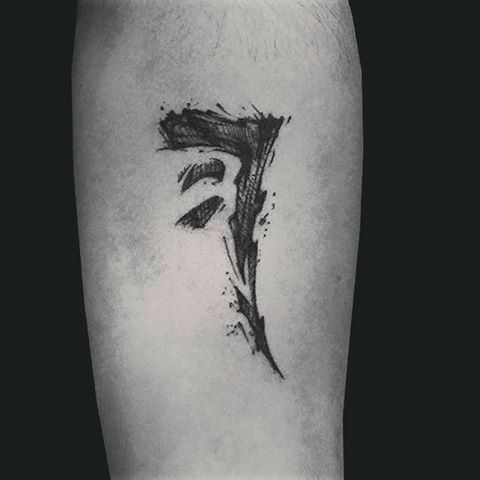 a black and white photo of the letter f tattoo on someone's left leg