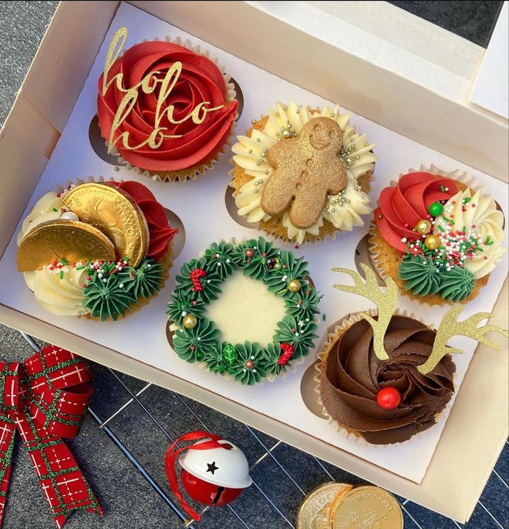 a box filled with cupcakes covered in frosting and decorated like wreaths