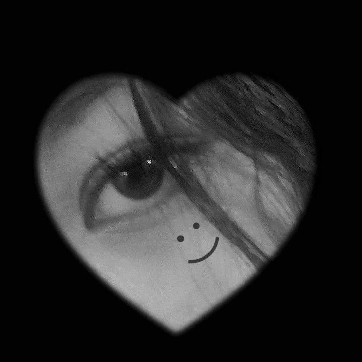 a woman's eye with a smiley face drawn on the side of her heart