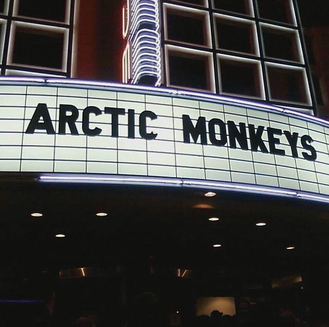 the marquee for arctic monkeys is lit up at night