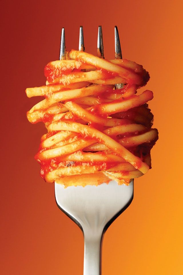 a fork full of french fries with ketchup on it's ends and forks sticking out