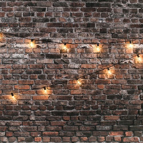 a brick wall with lights strung from it