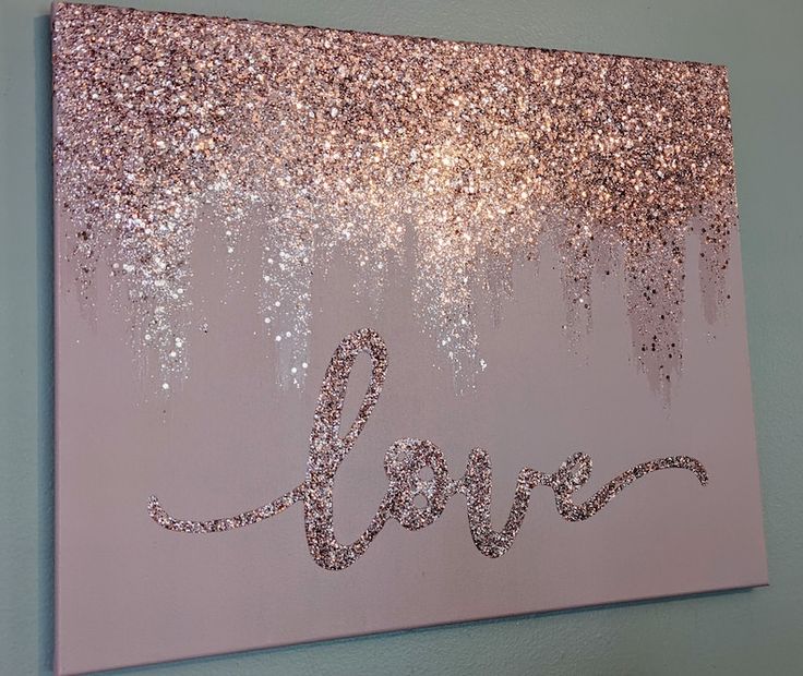 the word love is written in glitter on a pink background