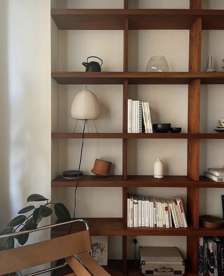 a bookshelf filled with lots of books next to a lamp