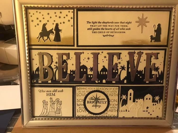 a framed christmas card with the words believe and nativity in black, white and gold