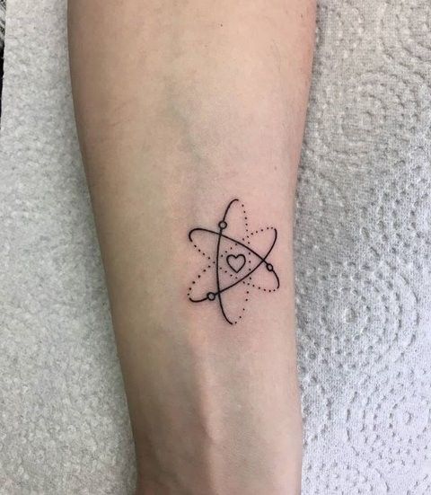 a small black and white tattoo design on the left arm, with an atomic symbol