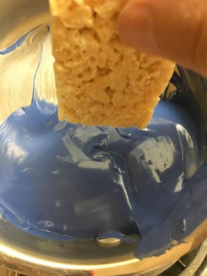 someone is dipping something into blue liquid in a bowl