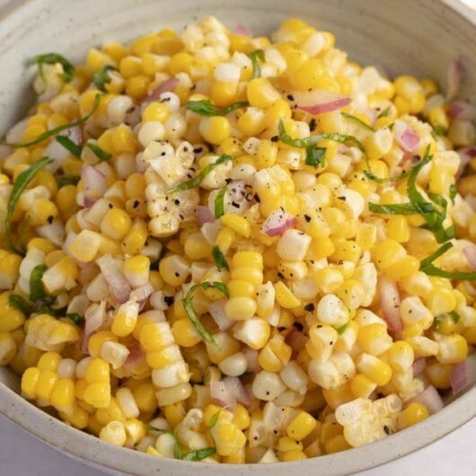 a white bowl filled with corn and herbs