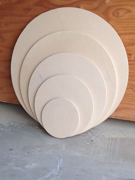 five white plates stacked on top of each other in front of a wood paneled wall