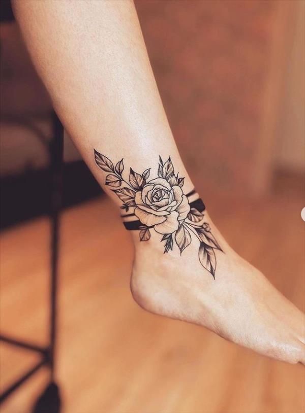 a woman's foot with a rose tattoo on it