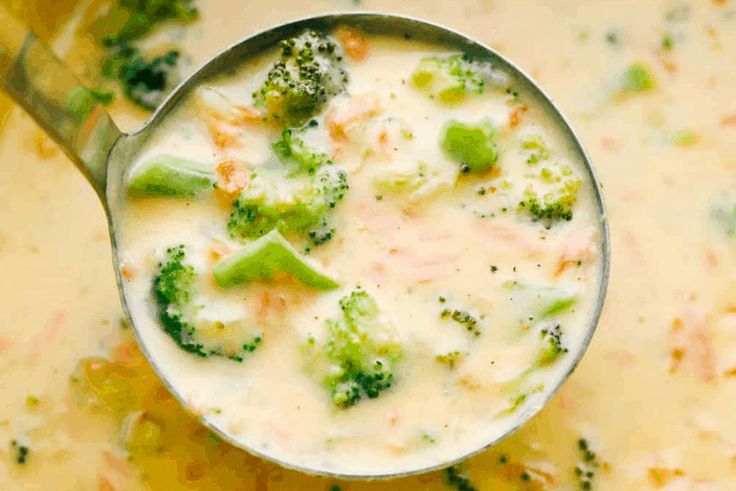 a spoon full of broccoli and cheese soup