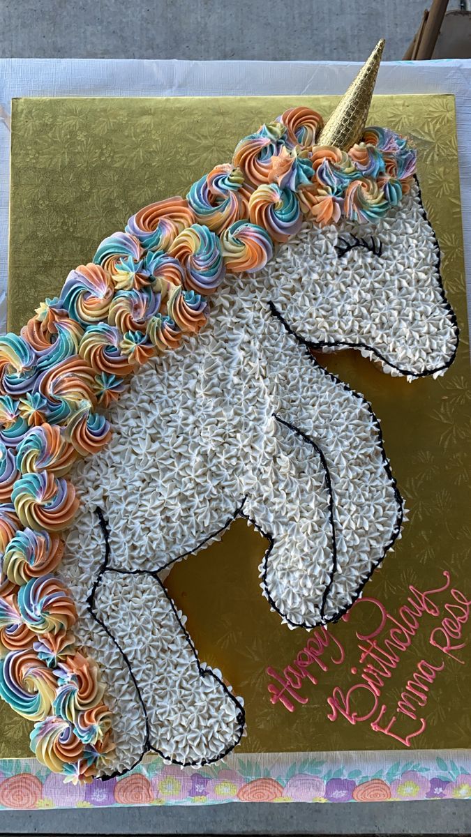 a birthday cake decorated like a unicorn with sprinkles