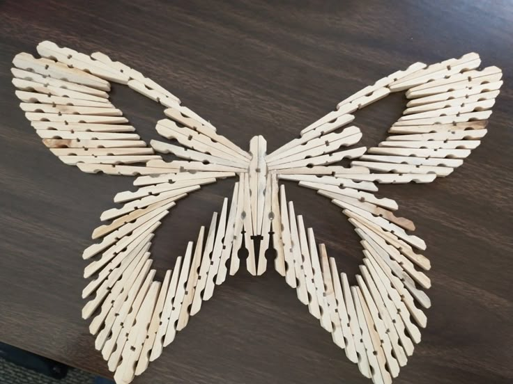 a wooden butterfly sculpture sitting on top of a table