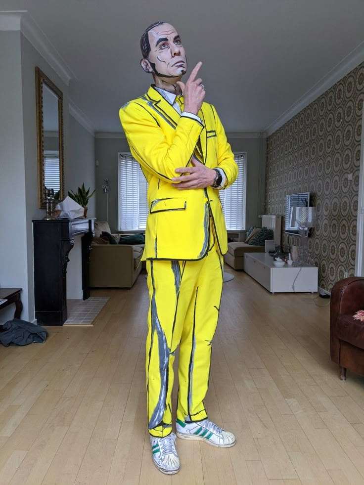 a man in a yellow suit standing on a hard wood floor