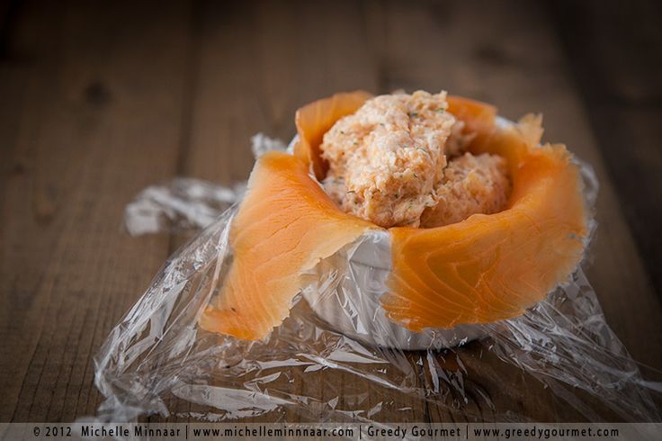 a piece of food wrapped in plastic sitting on top of a wooden table