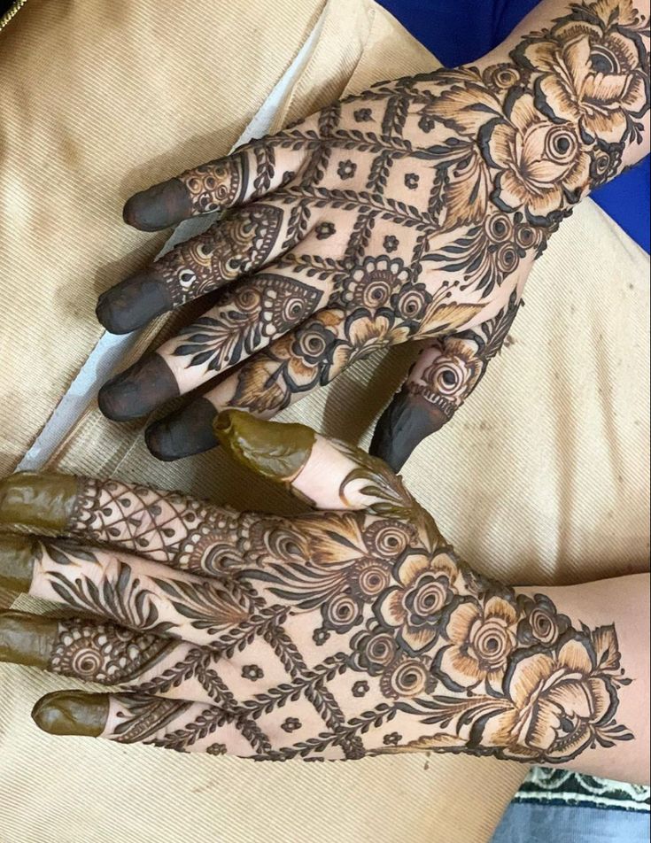 two hands with henna designs on them