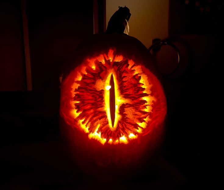 a pumpkin carved to look like an eye with flames coming out of the center and inside