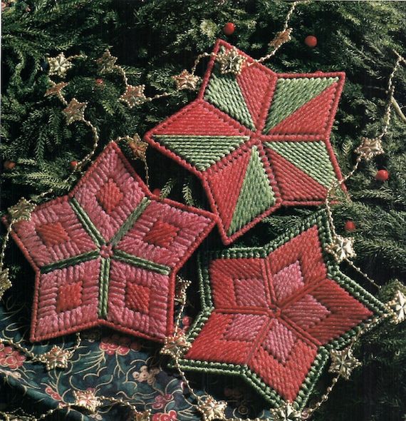 three red and green christmas ornaments sitting on top of a table next to a tree