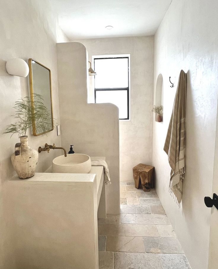 a white bathroom with two sinks and mirrors