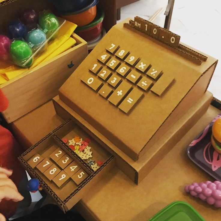 a child playing with a wooden toy set on a table in front of other toys