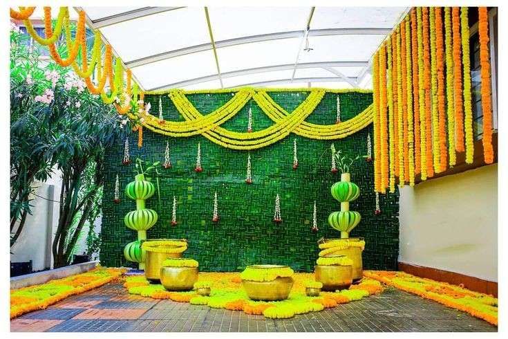 an indoor area decorated in yellow and green with lanterns, garlands and flowers on the wall