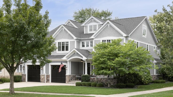 a large gray house with white trim and windows