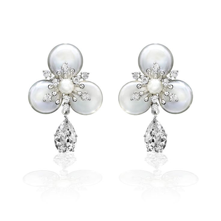 Exquisitely crafted, these earrings perfectly capture the romance of your special day. The design boasts a single pear-like cubic zirconia gemstone suspended elegantly from a luscious pearl flower. Crafted with utmost care, these earrings measure 1.5 inches long and are made from a durable alloy, free of lead, nickel, and cadmium. Matching bracelet here. Elegant Flower Shape Pearl Drop Earrings, Elegant Bridal Earrings With Pearl Drop In Flower Shape, Pear-shaped Pearl Drop Bridal Earrings In White Gold, Elegant Bridal Flower-shaped Pearl Drop Earrings, Flower Shaped Pearl Drop Earrings For Wedding, Elegant Flower Shaped Earrings With Pearl Drop, Flower-shaped Pearl Drop Earrings For Wedding, Elegant Flower-shaped Earrings With Pearl Drop, Formal Pearl Drop Flower-shaped Earrings