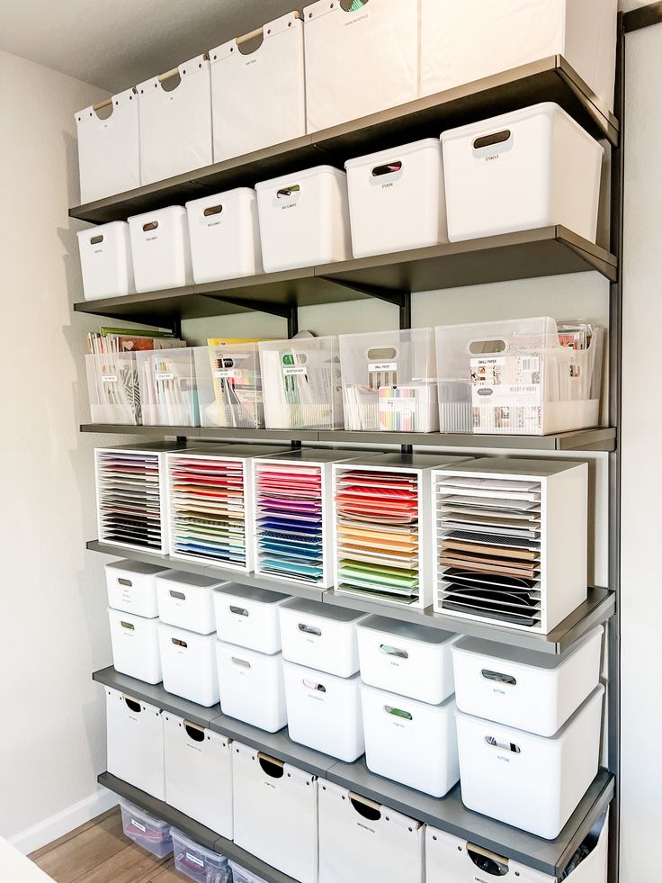 Beautifully organized wall of crafts in white and clear bins on grey shelves. Garage Craft Storage, Craft Station Storage, Stock Room Organization Retail, Ikea Arts And Crafts Storage Ideas, Craft Storage Shelves, Craft Supplies Organization Small Spaces, Art Shelves Organization, Office Organization Shelves, Craft Room Storage Wall