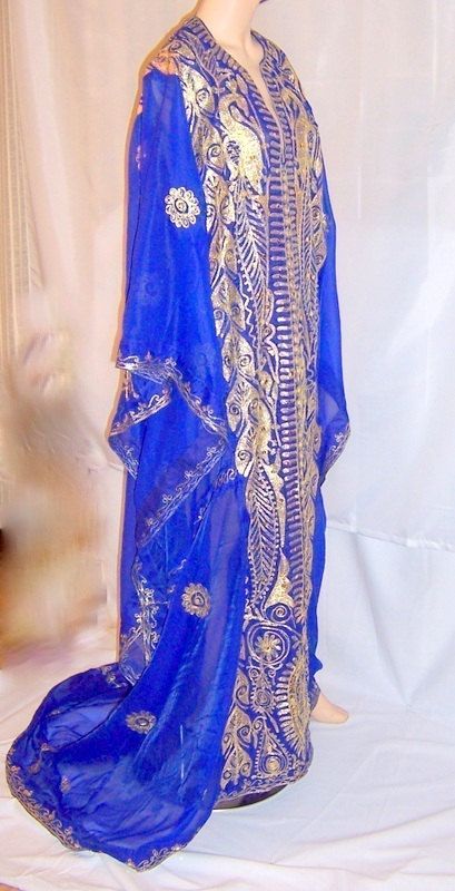 This is a magnificent Arabic electric blue wedding caftan of Middle Eastern origin. This wonderful silk fabric is exquisitely embroidered with gold metallic thread in Middle Eastern design motifs and accentuated with gold sequins. It is meant to be worn loosely and the electric blue fabric lends itself well to the diaphanous effect. It also has an extensive train which adds to its elegance. It is in excellent vintage condition and would be equivalent to any S/M/L figure type. Elegant Blue Thobe For Traditional Ceremonies, Gold Floor-length Thobe For Eid, Traditional Gold Floor-length Thobe, Gold Kaftan For Ceremonial Festivals, Gold Embroidered Thobe For Festivals, Gold Embroidered Floor-length Thobe, Embroidered Gold Floor-length Thobe, Festive Gold Thobe With Gold Embroidery, Traditional Gold Floor-length Kaftan