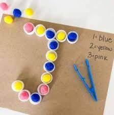 the letter e is made out of paper and colored pom poms with scissors