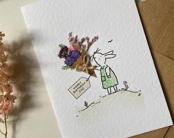 a card with a drawing of a person holding a bouquet of flowers on top of it