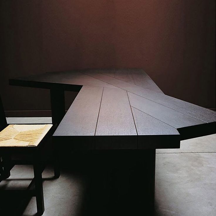 an empty table and two chairs in a room with a light shining on the wall