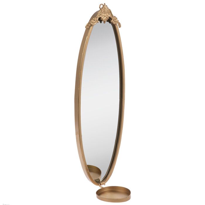 an oval shaped mirror with a gold stand on the side and a white back ground