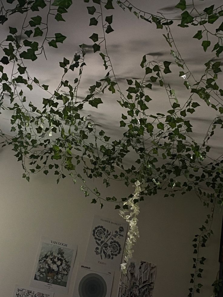 vines hang from the ceiling in an office space with posters on the wall and pictures hanging above