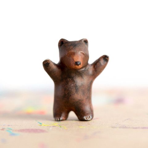 a small brown bear figurine sitting on top of a table