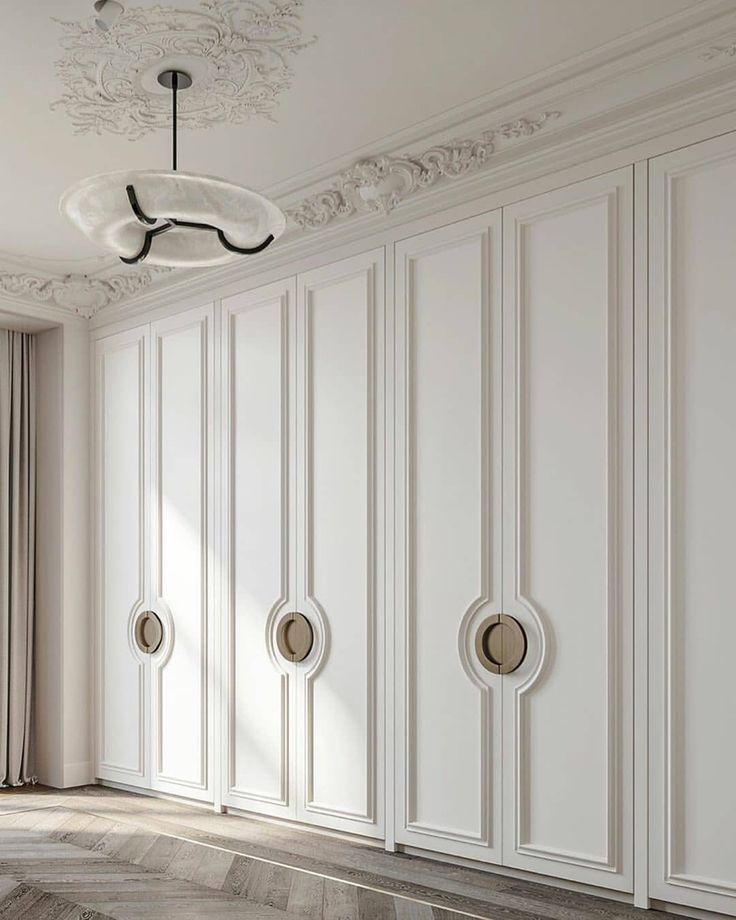 an empty room with white walls and wood flooring is pictured in this image, there are three round knobs on the doors