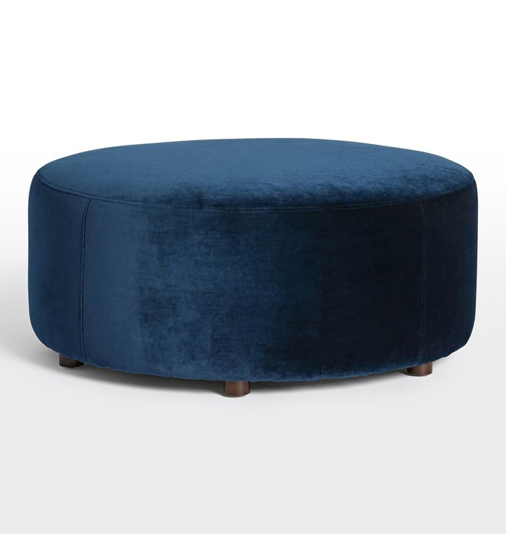 a round blue ottoman with wooden legs