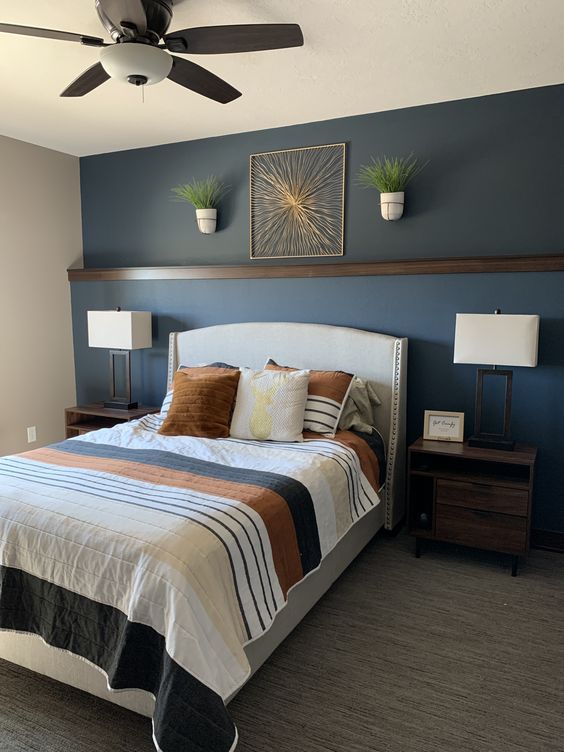 a bedroom with a bed, nightstands and ceiling fan