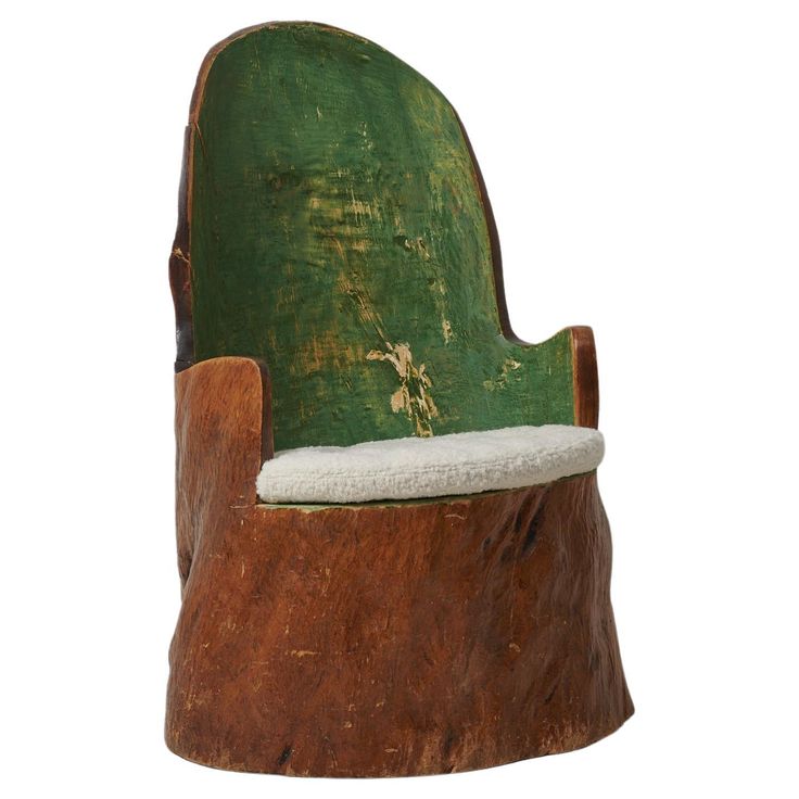 an old wooden chair with green paint and white fur on the seat is shown against a white background